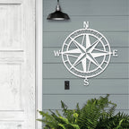Decorative nautical compass rose metal wall art on gray wooden wall with greenery at the bottom, coastal-themed décor, HouseSensationsArt