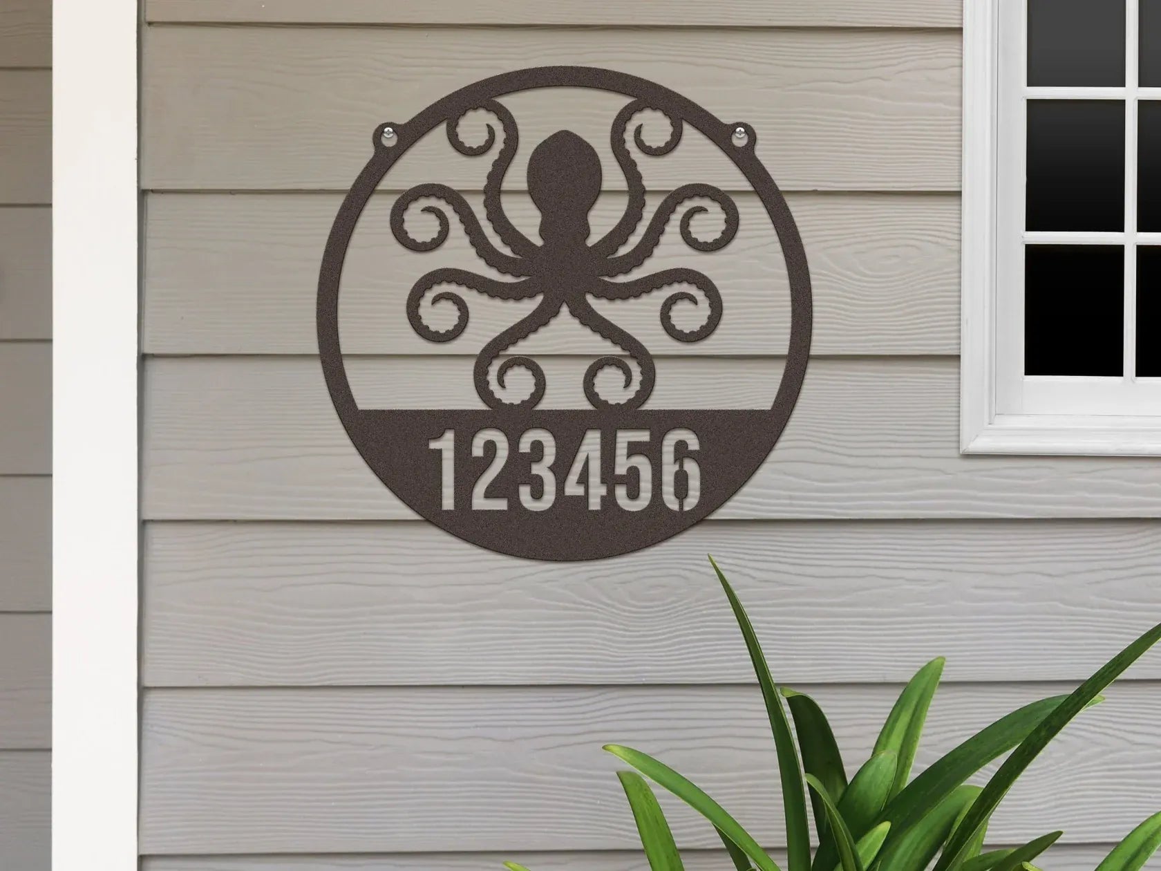 Round oil rubbed bronze Address Sign with house number '123456' and octopus design, mounted on door wall.