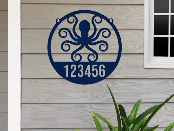 Round oil navy blue Address Sign with house number '123456' and octopus design, mounted on door wall.