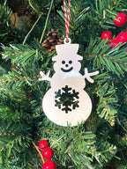 White snowman ornament hanging on Christmas tree with red berries, festive holiday decoration for seasonal décor and Christmas tree display