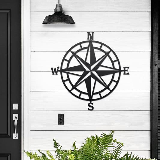 Personalized compass rose metal art for outdoor ligt black with plants in background 