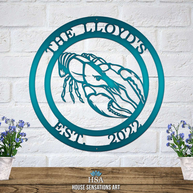 A candy teal custom laser cut metal sign showing crawfish in center, with “THE LLYOD’S EST 2022” text, outdoor nautical decor.