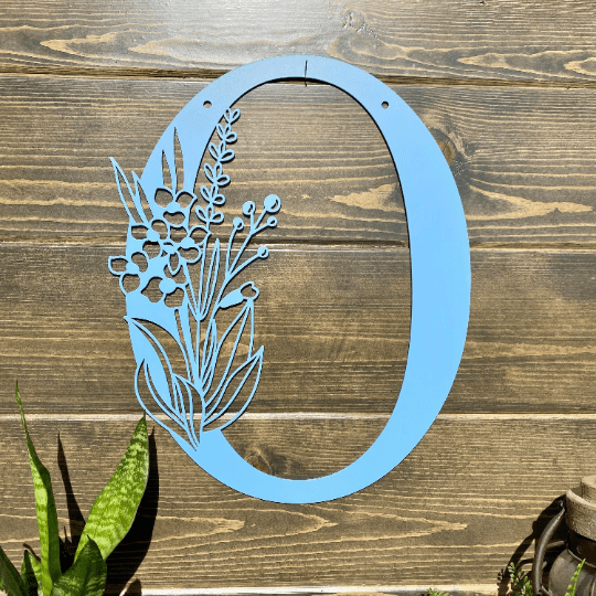 Personalized floral monogram metal door sign “O” in powder blue with floral design on wood background, farmhouse entry décor, custom front porch wall art