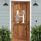 Personalized floral monogram metal door sign “H” on cream wood door, farmhouse entry décor, custom front porch wall art, light blue exterior background
