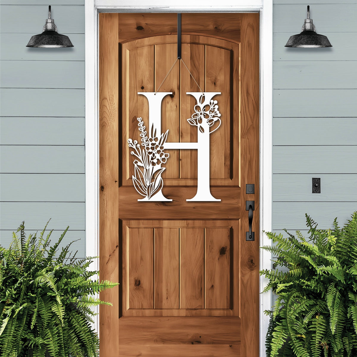 Personalized floral monogram metal door sign “H” on cream wood door, farmhouse entry décor, custom front porch wall art, light blue exterior background