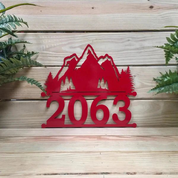 Red personalized metal house number sign with mountain design and “2063” on a wooden background, HouseSensationsArt