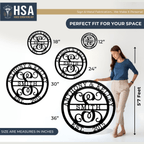 Woman standing next to large monogrammed metal art pieces with displayed measurements, featuring “HSA” branding, highlighting size, scale, and detailed craftsmanship of the custom designs.