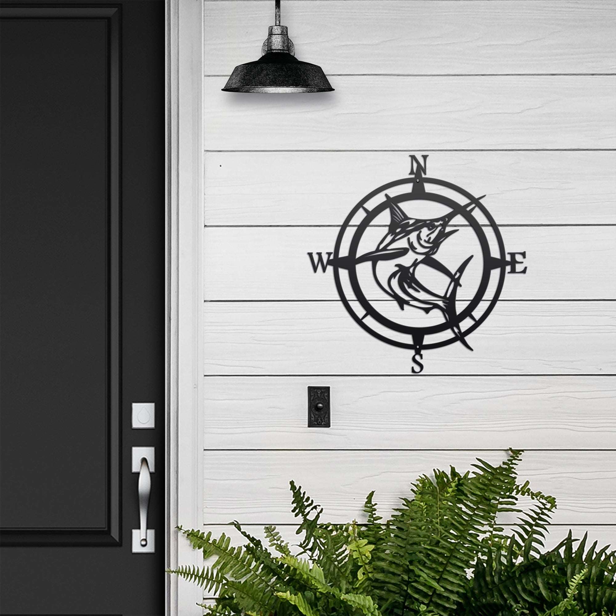 Decorative metal wall compass with fish design on white wooden wall, nautical-themed outdoor décor, custom home exterior accent