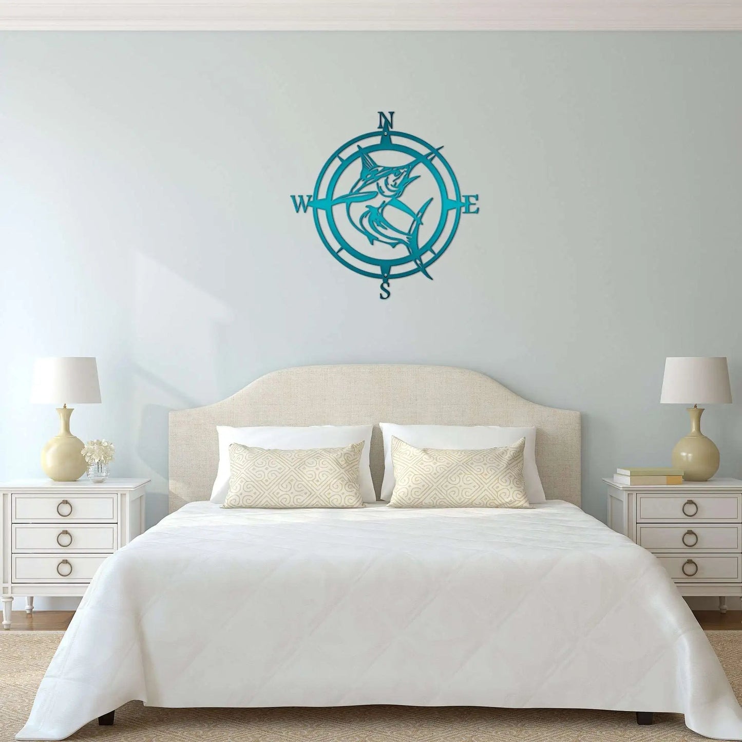Teal metal compass wall art above bed in bedroom with white walls and furniture, nautical-themed indoor décor, custom home wall accent