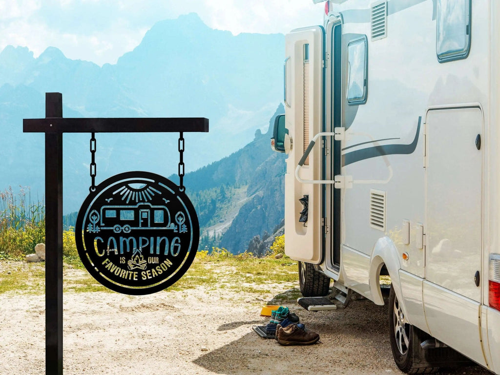 White RV parked in a scenic mountain setting with the door open, featuring a “Camping is my favorite season” sign, creating a peaceful outdoor adventure scene.