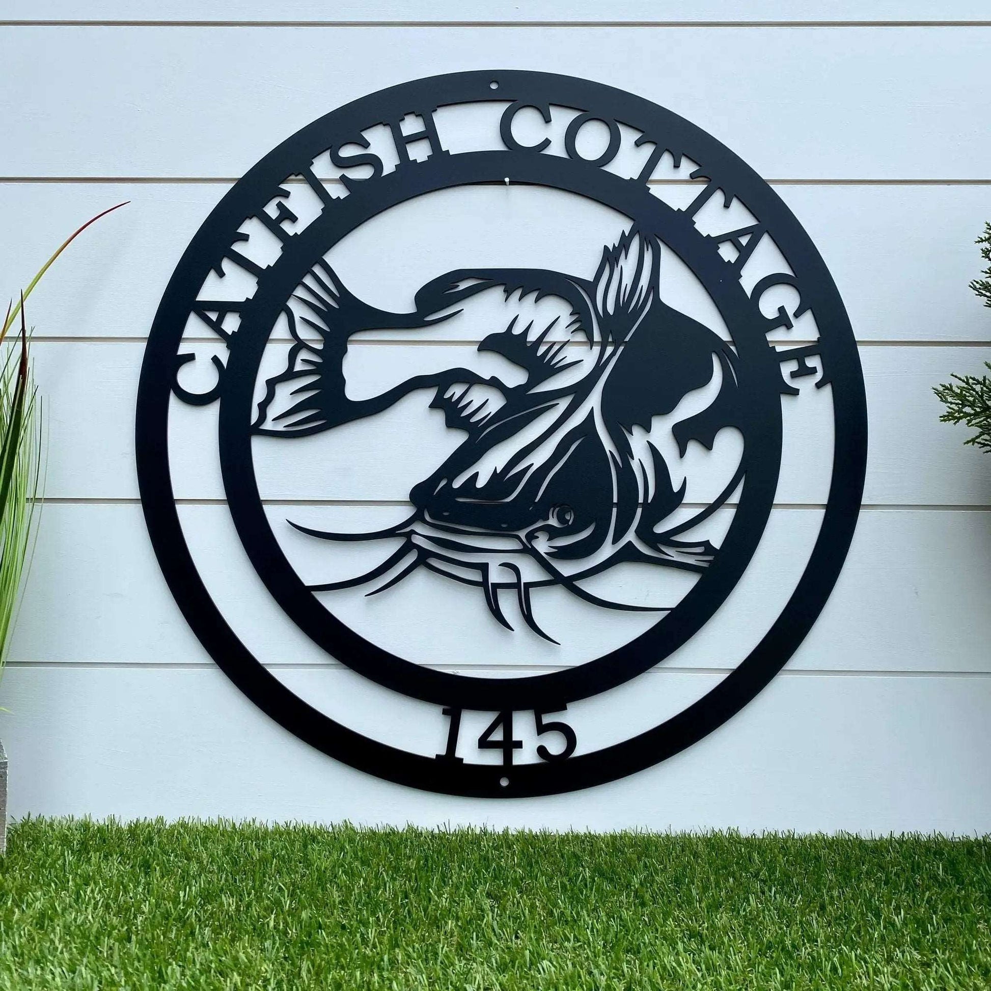 Custom black metal plaque with catfish and “CATFISH COTTAGE 145” ideal for outdoor fishing lodge decor
