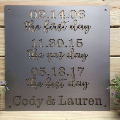 Metal plaque featuring engraved dates and names, displayed on a wooden background, showcasing personalized design, elegant detailing, and durable craftsmanship.