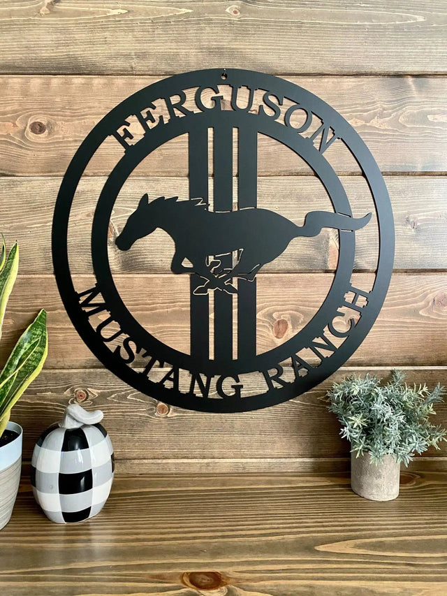 Black custom laser cut ranch sign with mustang silhouette and “FERGUSON MUSTANG RANCH” text, placed on rustic wood wall.