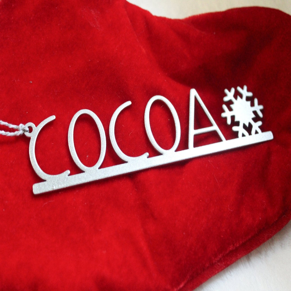 Personalized silver snowflake name tag COCOA, custom metal Christmas table décor place setting, laser cut holiday ornament on red festive background, HouseSensationsArt