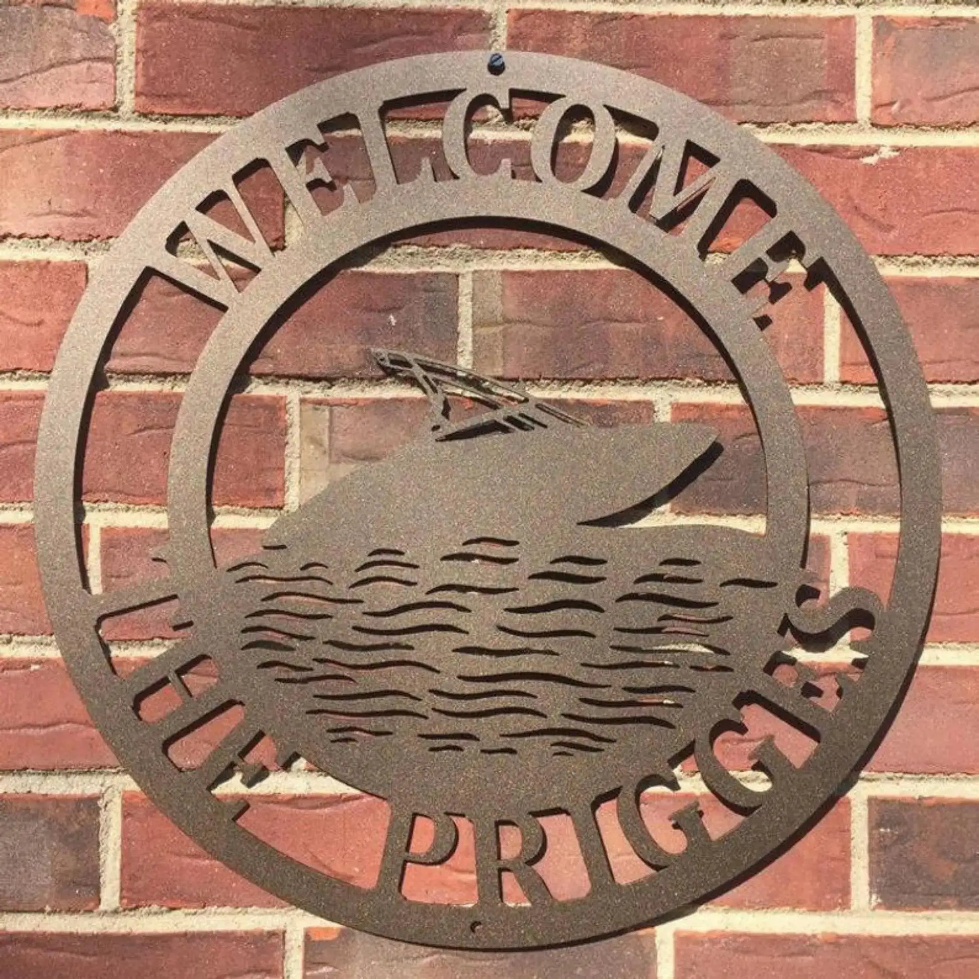 Personalized Speedboat Sign on a brick wall, showcasing custom street numbers. Crafted from durable metal, ideal for outdoor use as an address sign, blending boating passion with home décor.