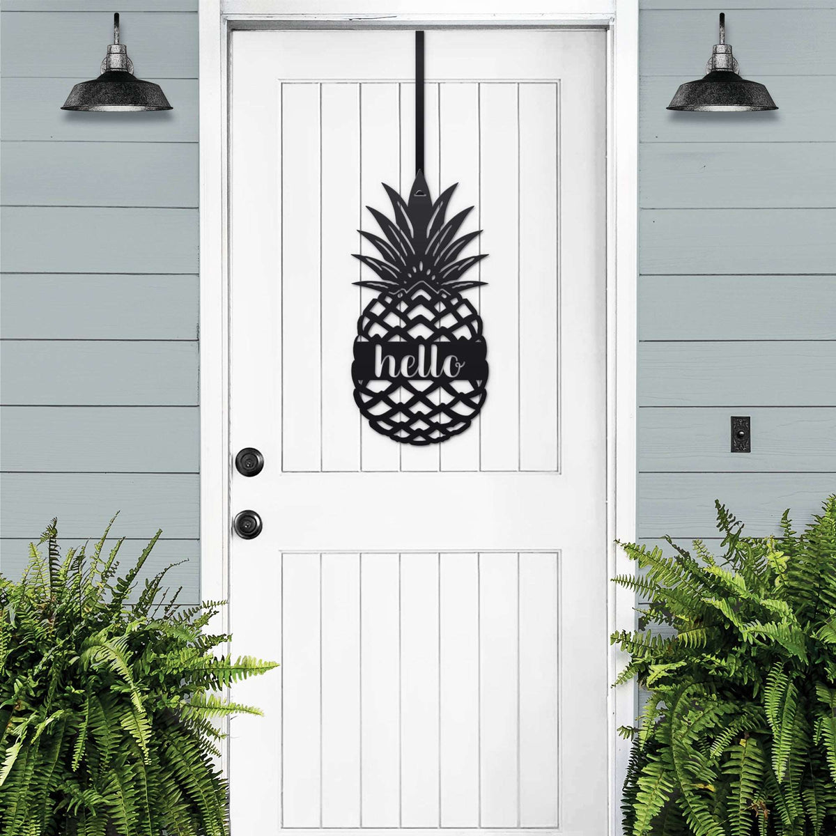 White front door with black pineapple hello metal sign decal, light blue wall and green plants, tropical farmhouse entry décor, custom powder coated welcome wall art sign