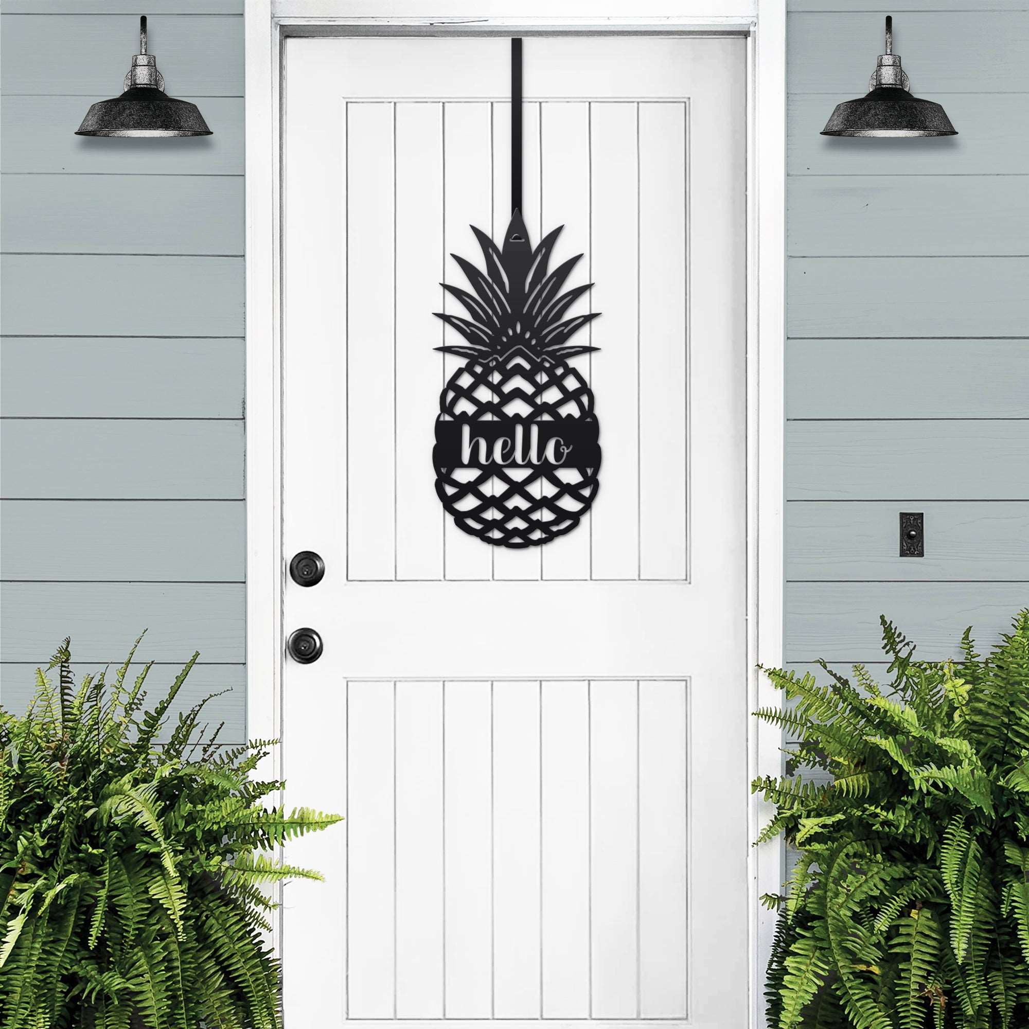 White front door with black pineapple hello metal sign decal, light blue wall and green plants, tropical farmhouse entry décor, custom powder coated welcome wall art sign