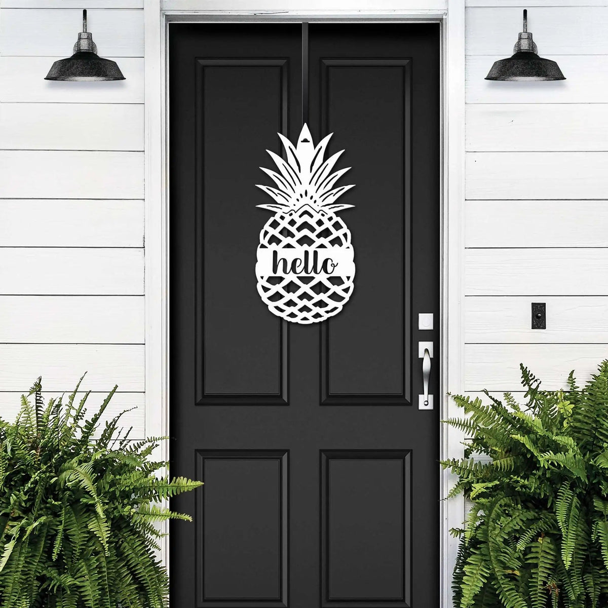Black front door with pineapple hello metal sign decal, white wall exterior with green plants, tropical farmhouse entry décor, custom powder coated welcome wall art sign