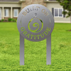 Decorative metal sign with text “Built on Gratitude” on grassy lawn, custom outdoor home décor, inspirational yard or garden accent