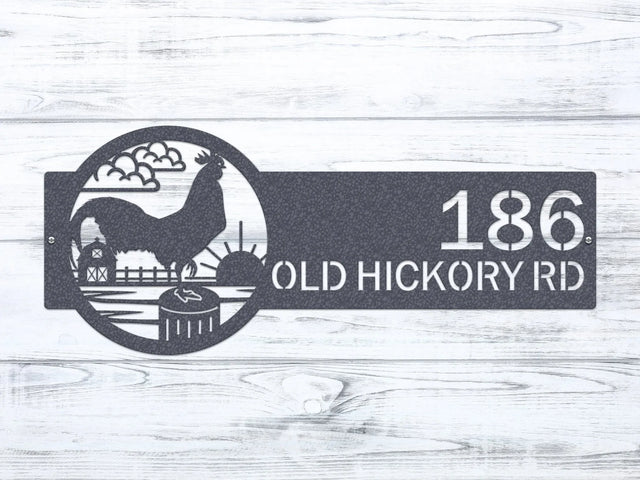 Black chrome Rooster Farm Address Sign with rooster, clouds, barn, and sun on right, and house number '186 Old Hickory Rd' on left.