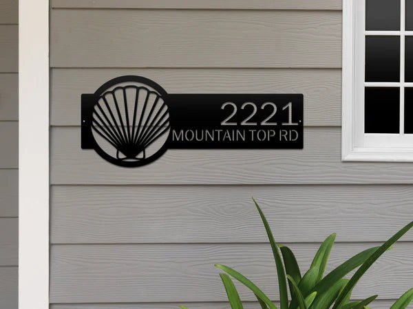 Seashell house number sign on exterior, personalized metal address plaque, coastal front door décor, outdoor nautical home sign.