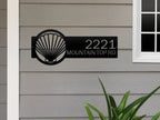 Seashell house number sign on exterior, personalized metal address plaque, coastal front door décor, outdoor nautical home sign.