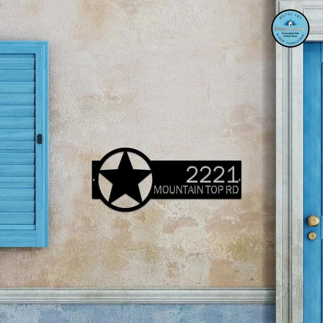 Black Star Monogram Address Sign featuring a star emblem on the right and house number '2221 Mountain Top Rd' on the left, mounted on a beige wall.