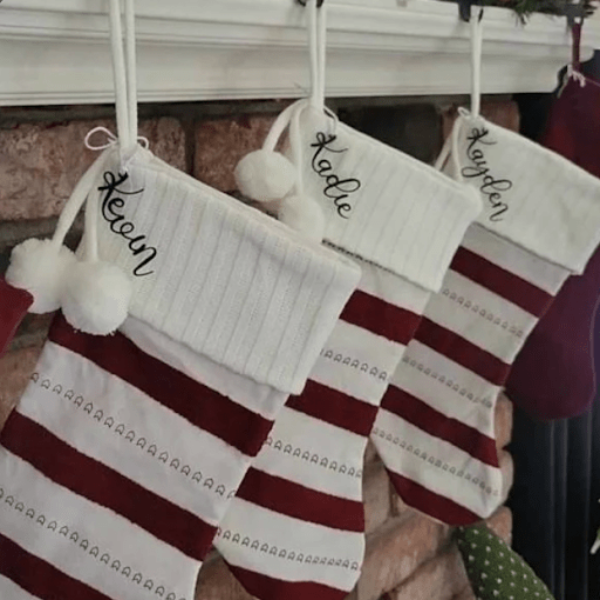 Red and white striped Christmas stockings with names hanging on fireplace, personalized festive holiday décor for seasonal home display