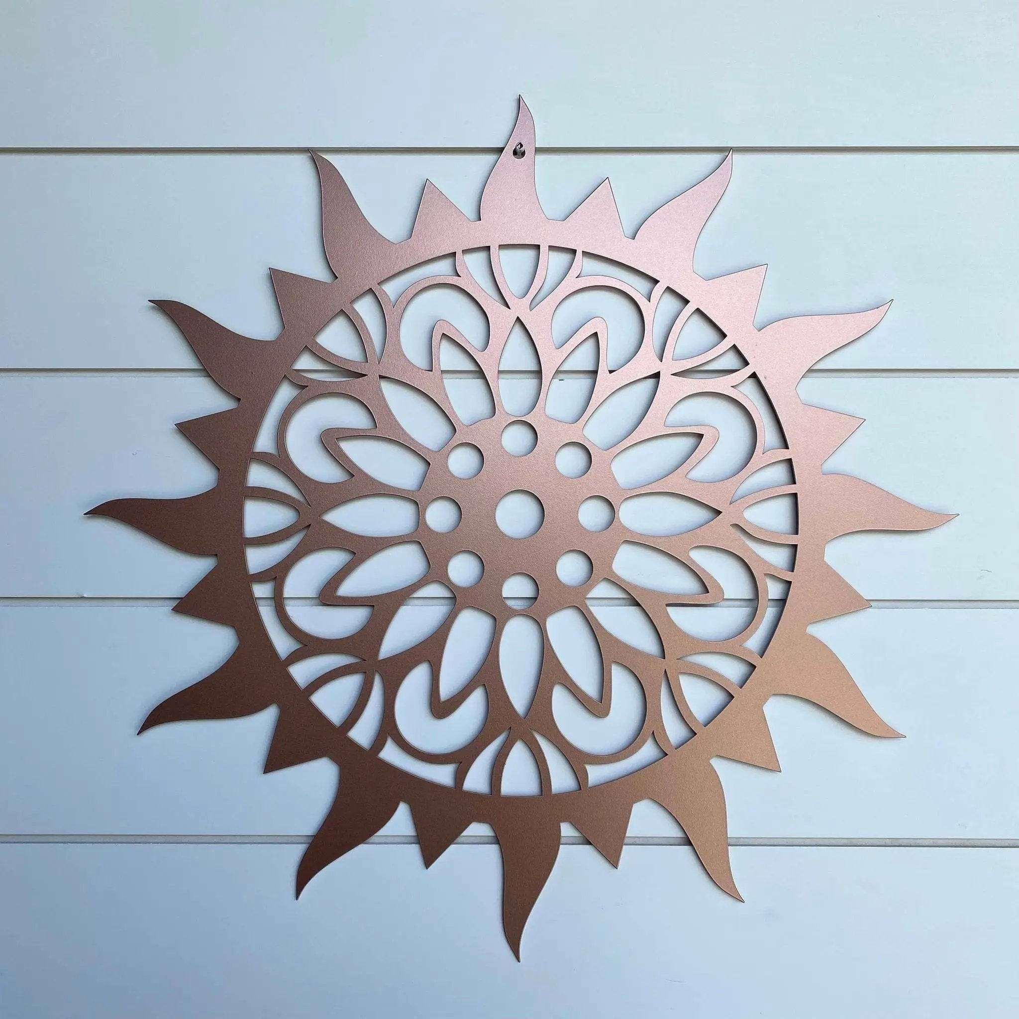 Sunburst metal sun wall art, decorative outdoor plaque mounted on light blue wooden background, powder coated for durability