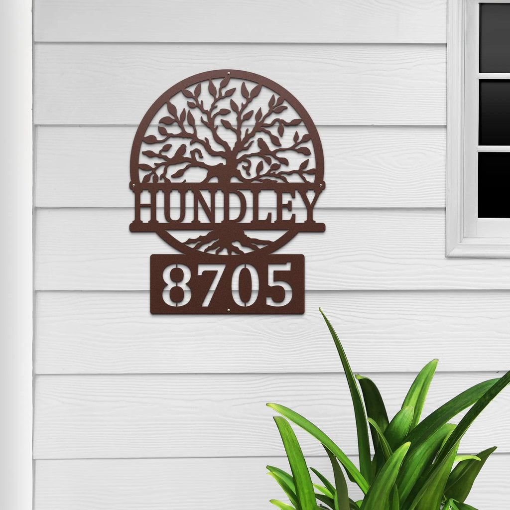 Decorative metal house number sign with tree design and text on house exterior, custom outdoor address plaque, modern home décor