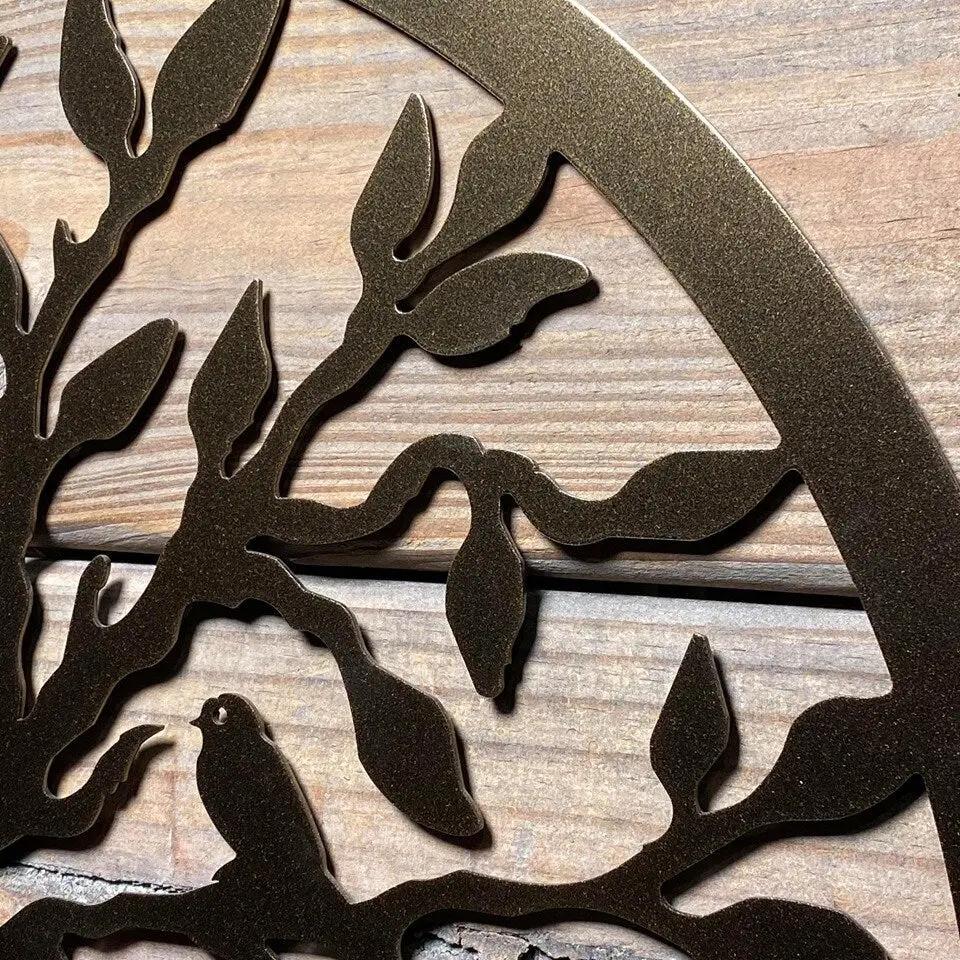 Decorative metal wall art with tree branches and bird design on wooden background, custom outdoor décor, nature-inspired home exterior accent