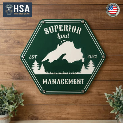 Hexagonal metal sign featuring a mountain design and “Superior Land Management” text, displayed on a wooden background with the “HSA” logo, highlighting rustic and professional branding.