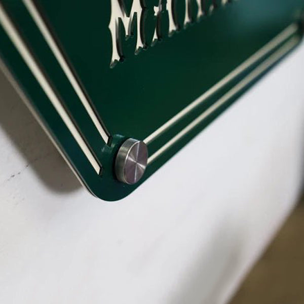 Close-up of a green metal object featuring a brand name, displayed on a white background, highlighting durable construction and detailed branding.