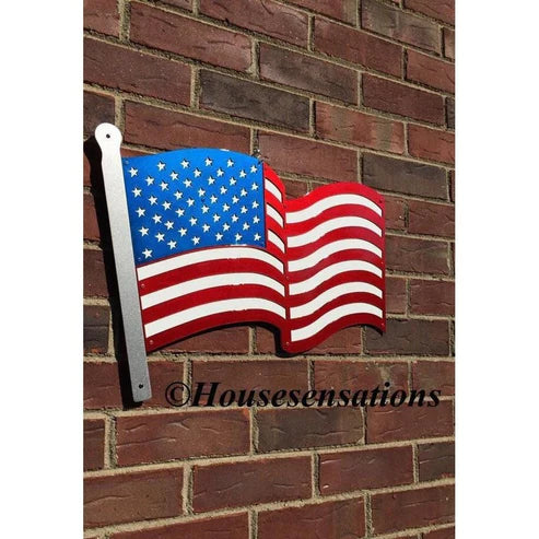 Stylized American flag with red and white stripes and white stars on blue, mounted on a brick wall with horizontal bricks.