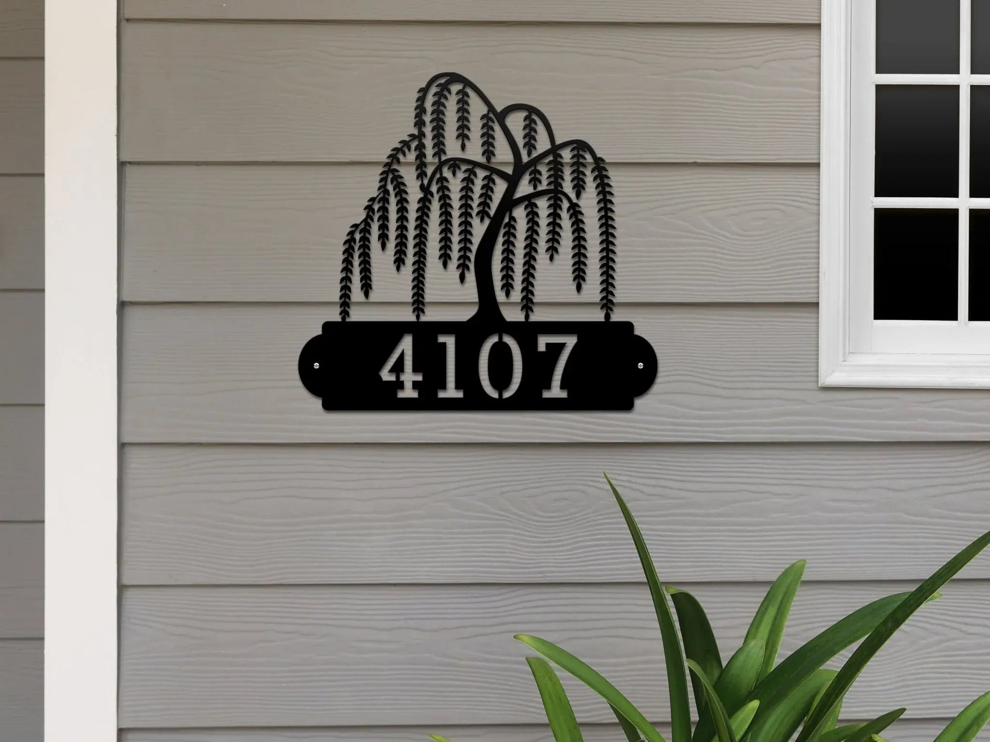 Black Weeping Willow Address Sign with tree design on top and house number '4107' below, mounted on gray door wall.