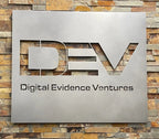 HouseSensationsArt custom metal sign with ‘Digital Evidence Ventures’ logo mounted on a stone wall using Weld Mount System strong adhesive fasteners, matte black powder-coated finish, durable outdoor-ready business signage, modern metal wall décor.