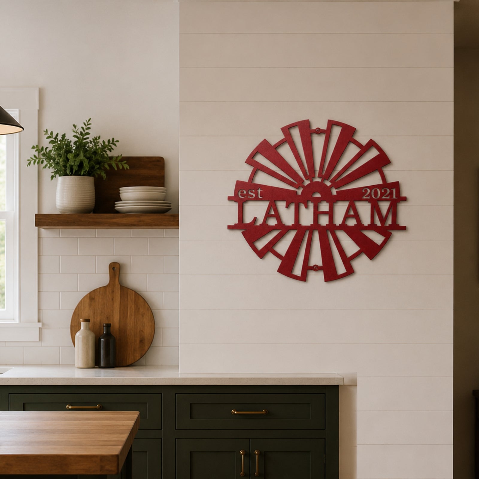 Personalized red metal windmill wall decor featuring the name "Latham" and "est 2021," mounted on a white shiplap wall in a modern farmhouse kitchen setting.
