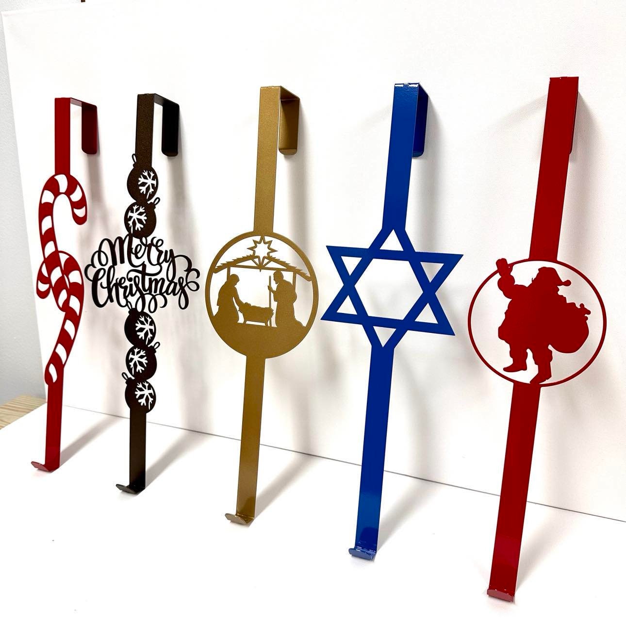 Christmas Metal Over-Door Hook for Wreath Hanger showcasing various festive designs including a blue star and nativity scene, highlighting its customizable and durable metal construction, perfect for home or garden décor.