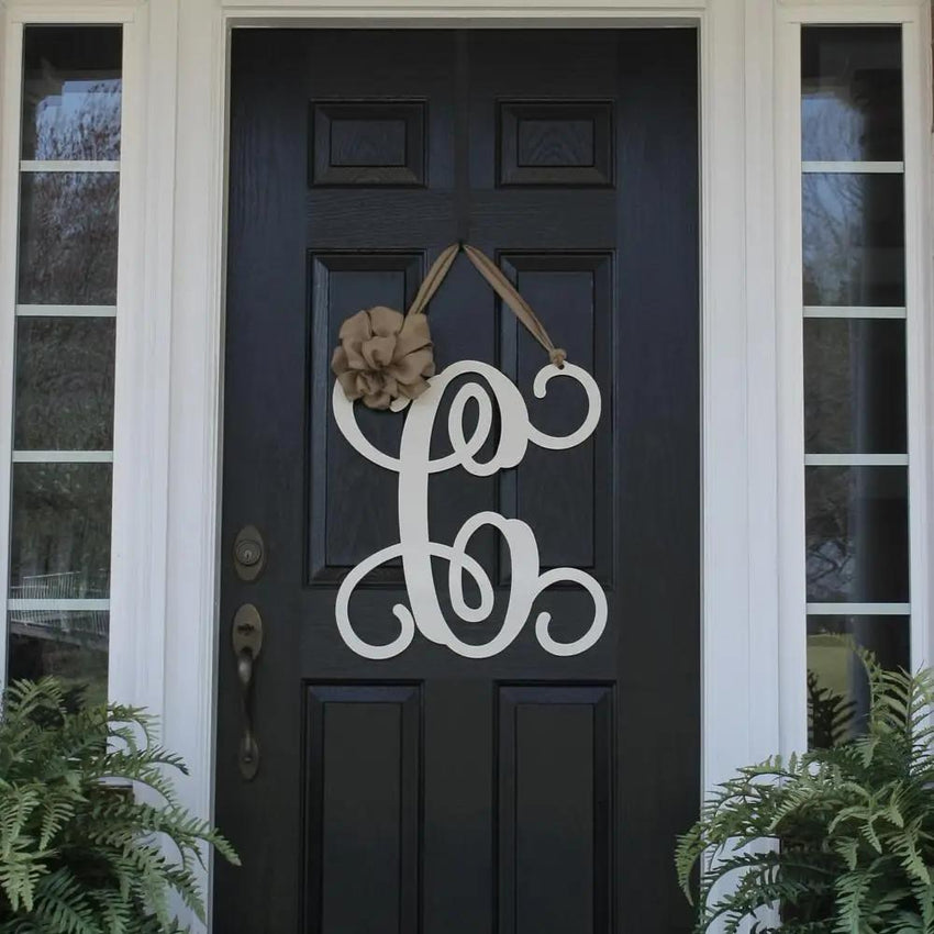 White personalized metal initial door wreath displayed on a close front door
