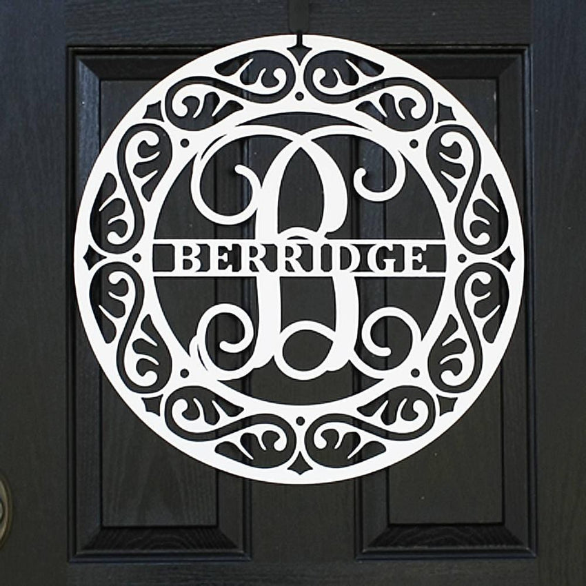 White personalized metal monogram crest door wreath on a black door