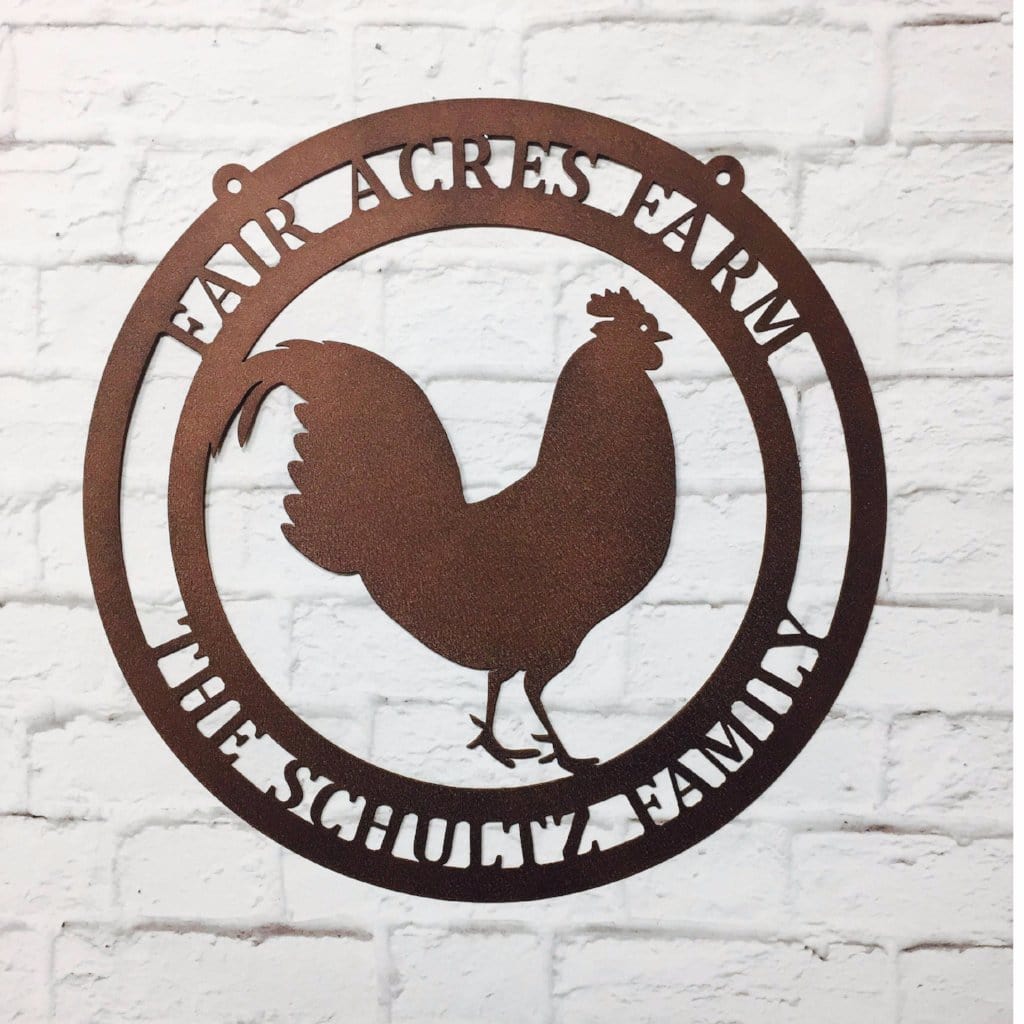 Oil rubbed bronze circular ranch metal sign with cut-out rooster and “IMGRUND-FLINT COOP EST. 2019” text on brick wall.