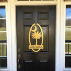 Decorative metal “Welcome” sign with palm tree design on black door, custom outdoor home entrance décor