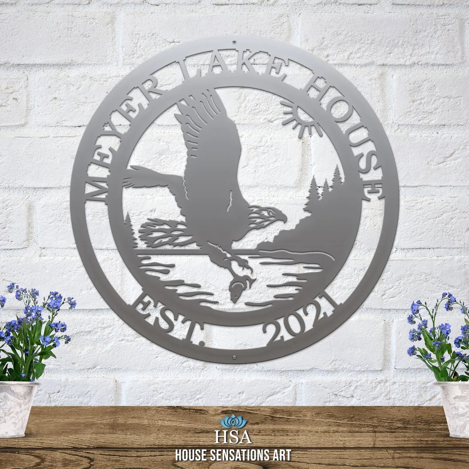 Polished chrome eagle sign with sun, lake, and trees personalized laser cut metal nameplate for fishing lodge wall decor.