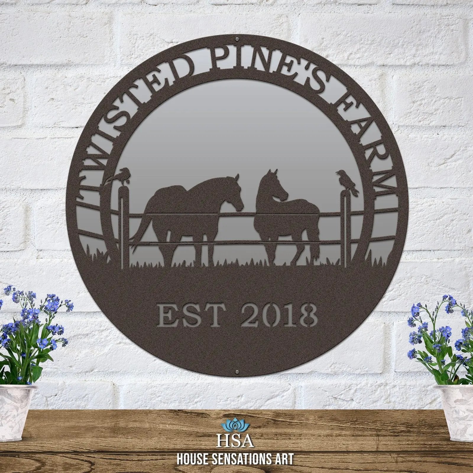 An oil rubbed bronze custom laser cut metal ranch sign showing horses in pasture, with “TWISTED PINE’S FARM EST 2018” text.
