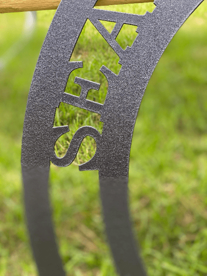 Close-up of grey seahorse sign showing laser-cut “SEA” text detail and metal texture, highlighting precision cut.