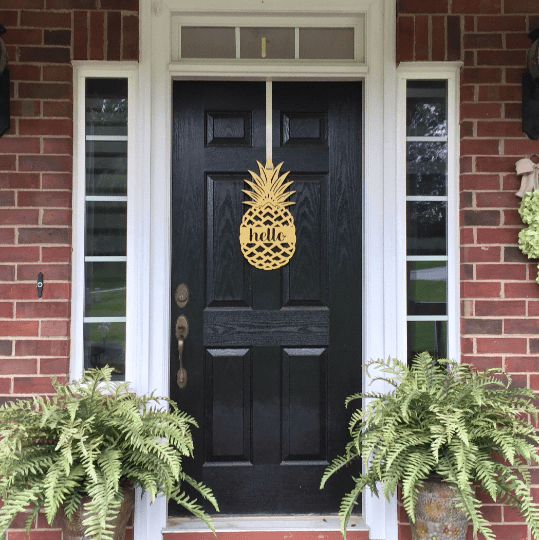 Black front door with gold pineapple metal sign, brick exterior home entry, tropical farmhouse curb appeal décor, custom powder coated welcome wall art sign