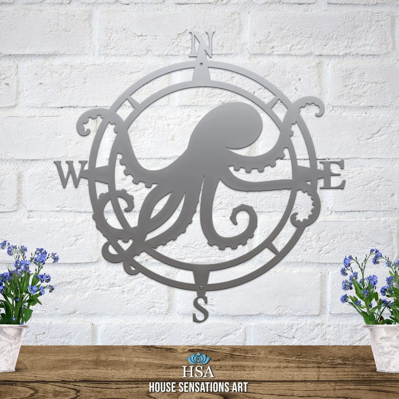 Polished chrome metal compass sign with octopus silhouette in center, arms stretching W and E; nautical home entry accent.